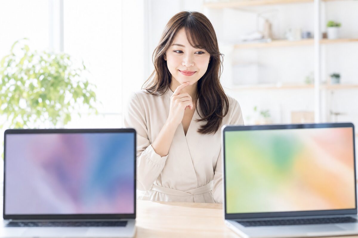 2つの動画編集画面を見比べる会社員
