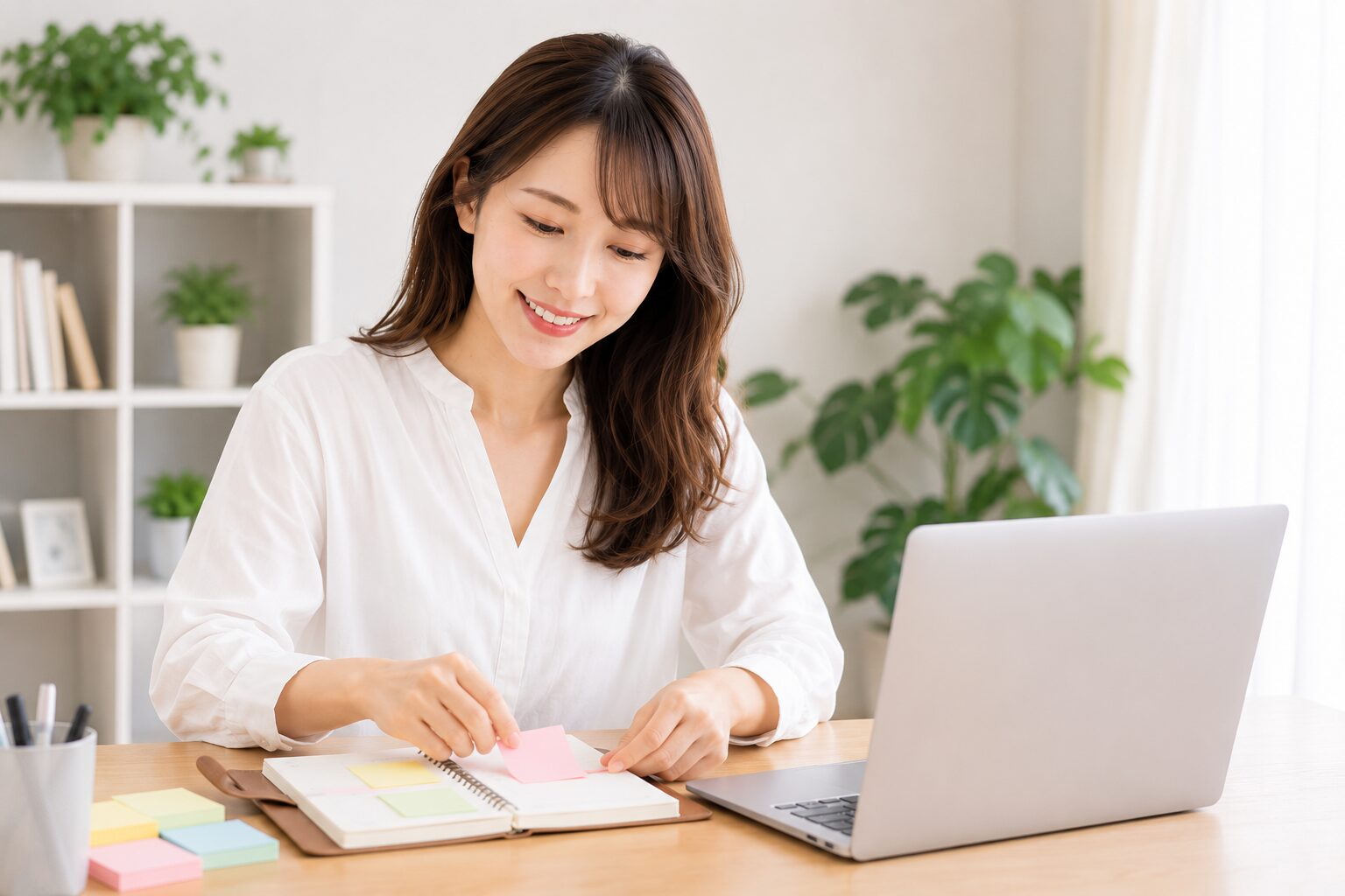 ノートPCで調べながら付箋でキーワードを整理する女性