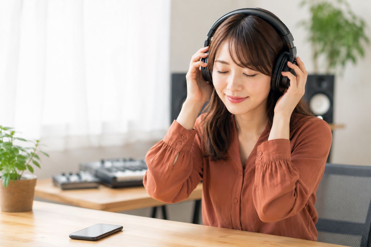 ヘッドホンでBGMを聴き比べる女性